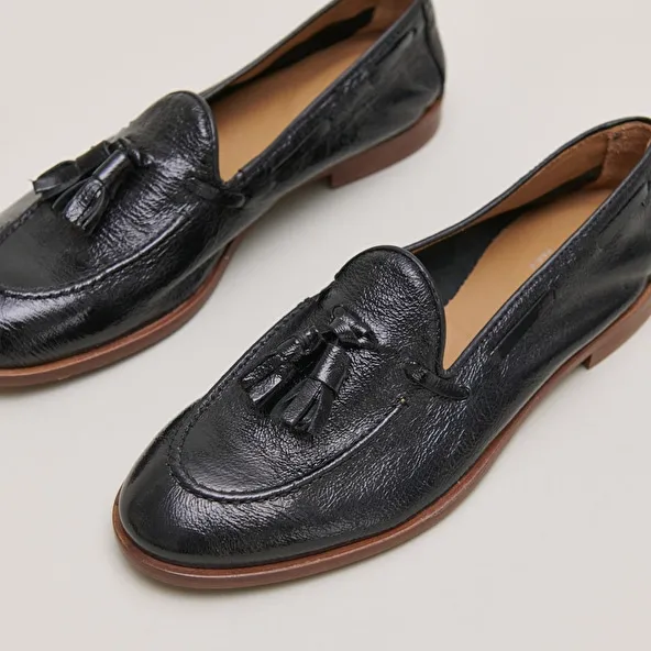 Round toe loafers with pompons in black pleated patent